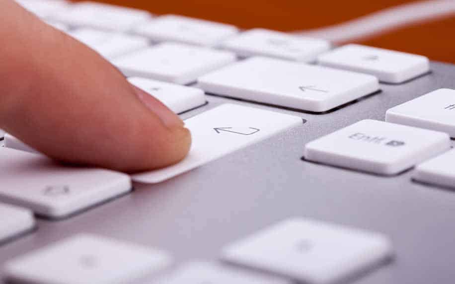 a person typing out keywords for seo on their computer keyboard